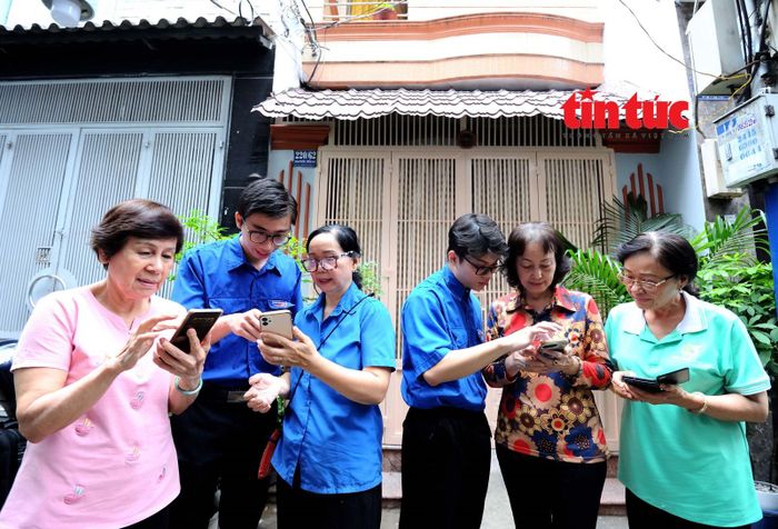 Đoàn viên thanh niên phường Diên Hồng hỗ trợ các đảng viên khu phố 22 cài đặt ứng dụng "Sổ tay Đảng viên" sau lễ ra quân.