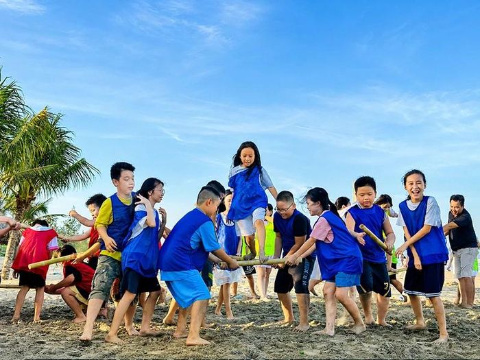 Học sinh tham gia hoạt động teambuilding trên bãi biển.