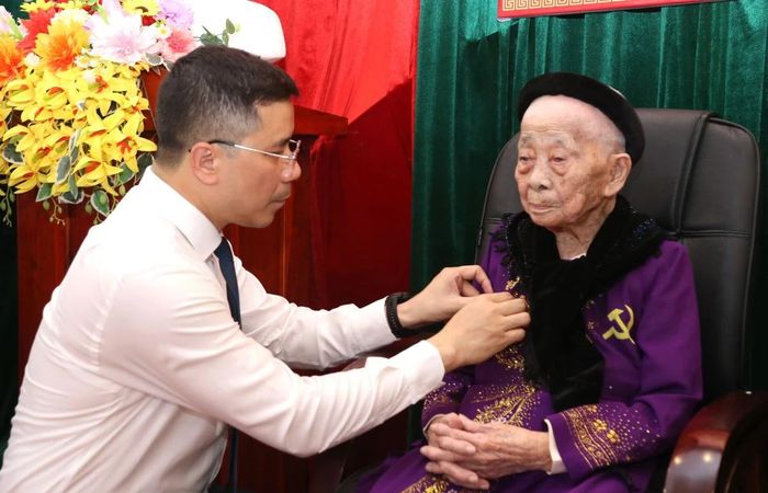 Đồng chí Nguyễn Hồng Phong, Ủy viên dự khuyết Trung ương Đảng, Phó Bí thư Thường trực Tỉnh ủy, Chủ tịch HĐND tỉnh trao Huy hiệu 80 năm tuổi Đảng cho đảng viên Đồng Thị Đài.