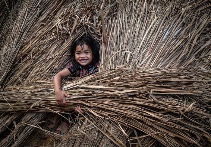 Trẻ em chơi trò trốn tìm bên những ụ tranh dựng làm mái nhà.