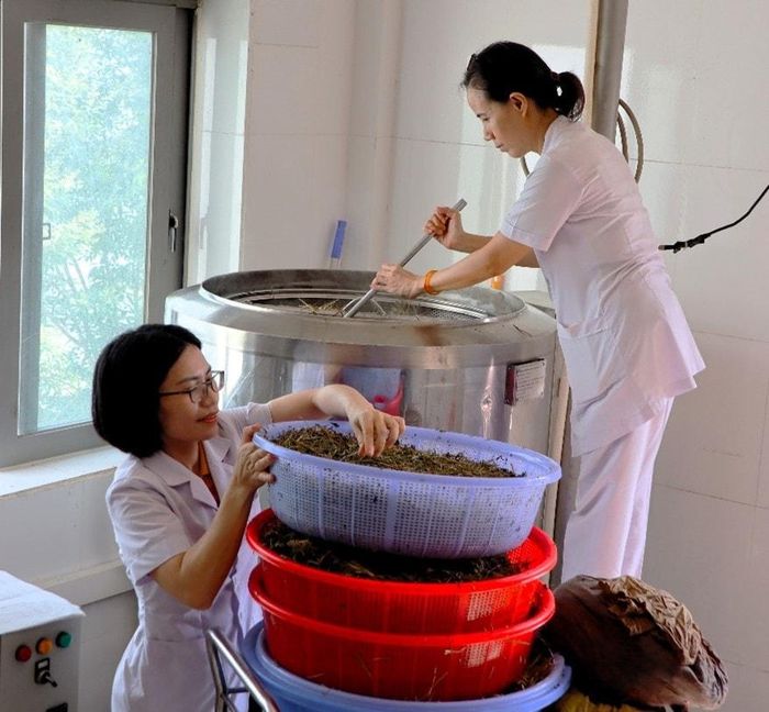 Cho thuốc vào hệ thống lò để nấu cao. Ảnh: N.H