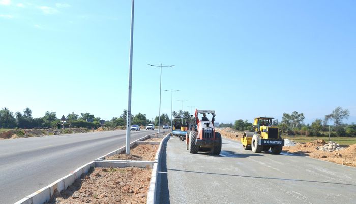 Thi công nền đường cấp phối đá dăm qua xã Tam Xuân. Ảnh: CÔNG TÚ