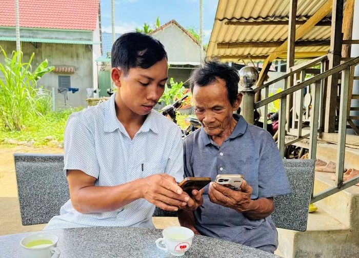Ông Đinh Văn Pấy (bìa trái) - Bí thư chi bộ kiêm Trưởng thôn T6 (xã Ân Tường) hướng dẫn đảng viên nhận diện thông tin xấu, độc trên mạng xã hội. Ảnh: N.H