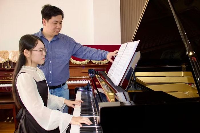  Anh Vũ Thiên Vũ - giáo viên Trung tâm Duy Vũ Music - hướng dẫn Đan Thanh hoàn thiện kỹ thuật và cảm xúc trong từng bản nhạc. Ảnh: Minh Chí 