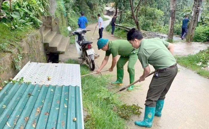 Lực lượng Công an xã Chế Tạo tham gia vệ sinh môi trường cùng người dân địa phương.