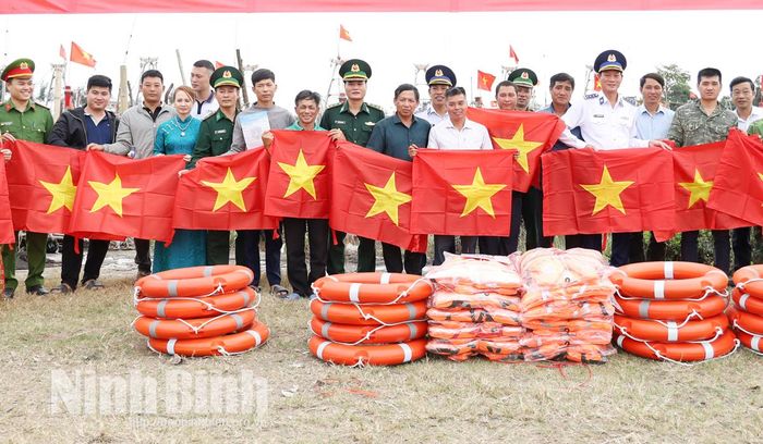 Lực lượng chức năng trao tặng phao cứu sinh, áo phao, cờ Tổ quốc… đồng hành cùng ngư dân xã Rạng Đông vươn khơi.