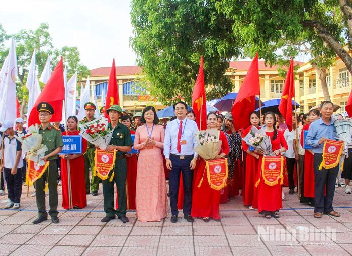 Đồng chí Phạm Thị Thu Hằng, Ủy viên Ban Thường vụ Tỉnh ủy, Giám đốc Báo và phát thanh, truyền hình Ninh Bình và lãnh đạo xã Bình An tặng cờ lưu niệm cho các đoàn tham gia Đại hội.