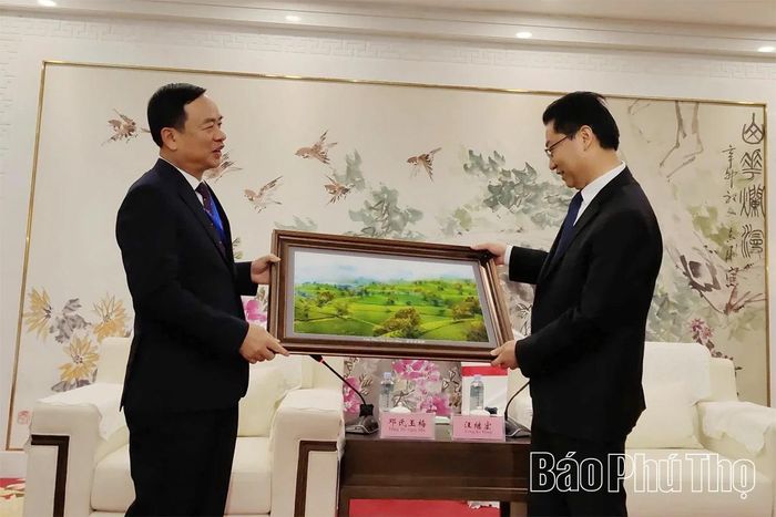 Đồng chí Phó Chủ tịch UBND tỉnh Quách Tất Liêm trao bức tranh Đồi chè Long Cốc tặng lãnh đạo thành phố Bạc Châu.