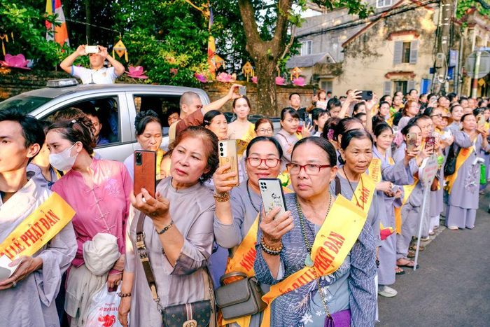 Phật tử đứng hai bên đường cung đón đoàn rước Phật đi qua.