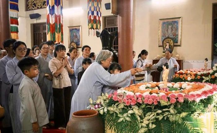 Bà hướng dẫn cháu trang nghiêm cử hành nghi lễ Tắm Phật