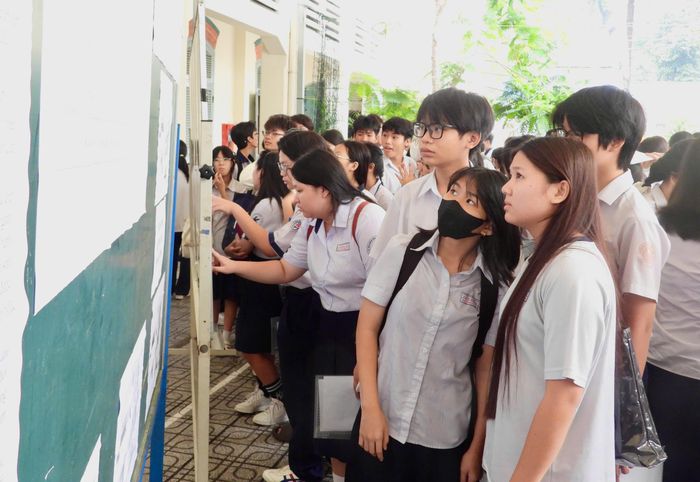 Học sinh chăm chú dò tìm số báo danh và vị trí phòng thi trước ngày thi chính thức.