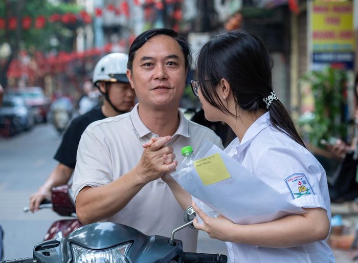 Khoảnh khắc phụ huynh nắm tay động viên con trước giờ thi. Ảnh: Mạnh Hưng