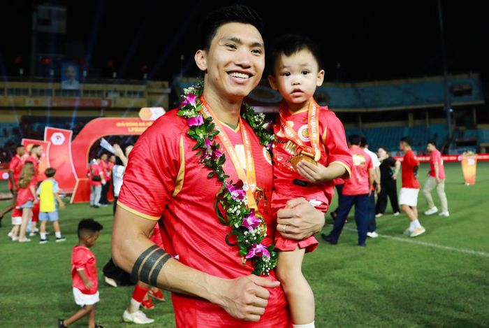 Văn Hậu chung vui với con trai trong buổi lễ.
