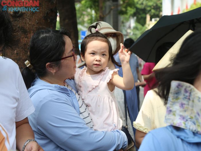 Em bé theo mẹ đến đón chị tại điểm thi.
