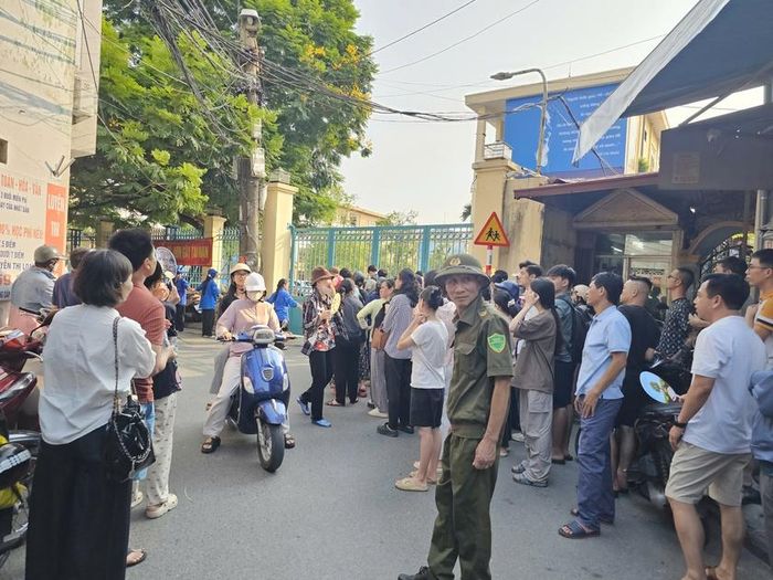 Phụ huynh đứng chờ thí sinh tại điểm thi trường Trung học phổ thông Trần Nguyên Hãn. Ảnh: Tuệ Nhi