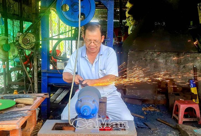 Ông Trần Văn Tân tỉ mẩn hoàn thiện sản phẩm rèn vừa mới tạo hình.