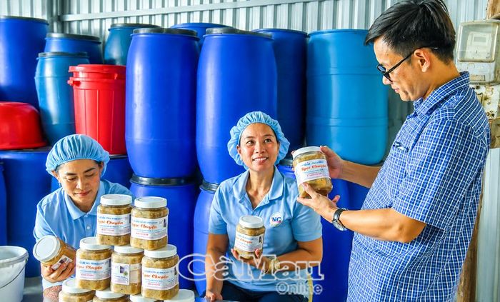 Ông Nguyễn Minh Luân, chuyên viên phòng Kinh tế xã Tân Ân, tham quan cơ sở mắm cá sơn Ngọc Chuyển, sản phẩm OCOP đặc trưng của địa phương.