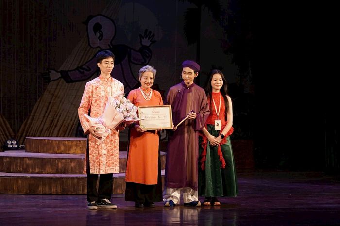 Đại diện Ban Tổ chức dự án “Ngân điệu Chèo” trao Giấy chứng nhận tới NSƯT Ngọc Ánh, ghi nhận sự đồng hành và những đóng góp của nữ nghệ sĩ trong hành trình lan tỏa nghệ thuật chèo đến khán giả trẻ. Ảnh: PV