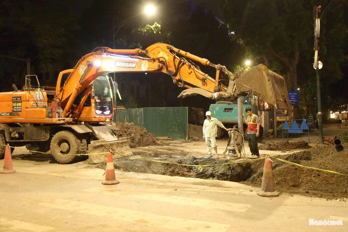 Các tổ công nhân thay ca làm việc xuyên đêm trên tuyến phố Quang Trung, một trong những hạng mục trọng điểm của Dự án xử lý úng ngập cục bộ khu vực nội đô. Ảnh: Lại Tấn