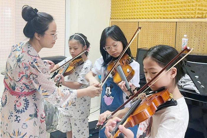 Giáo viên tại Cung Thiếu nhi Hà Nội tận tình hướng dẫn trẻ học đàn. Ảnh: Đỗ Tâm.