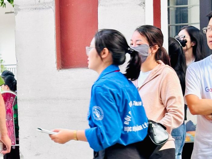 Lực lượng tình nguyện kịp thời giao máy tính cho Hội đồng thi để chuyển cho thí sinh bị quên. Ảnh: Thanh Hà