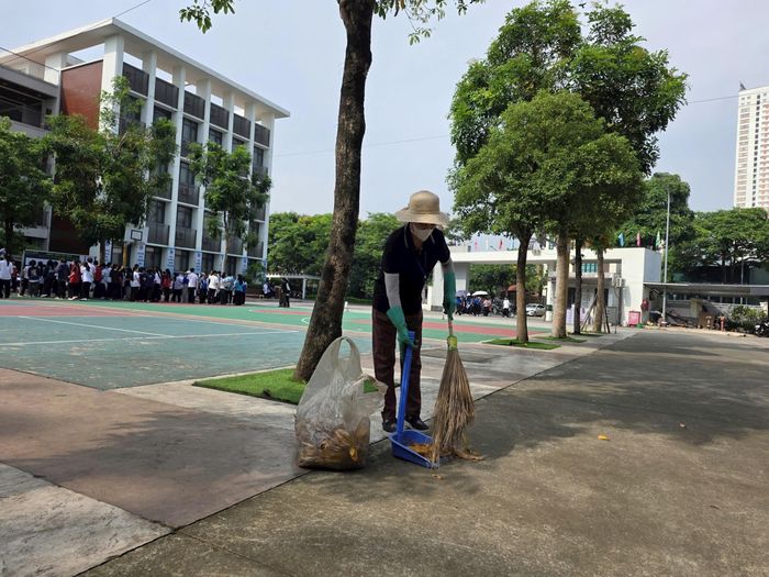 Nhân viên lao công tại điểm thi lặng lẽ thực hiện công việc vệ sinh, chuẩn bị cơ sở vật chất, góp phần bảo đảm môi trường thi sạch sẽ, ngăn nắp trong suốt kỳ thi vào lớp 10. Ảnh:MK