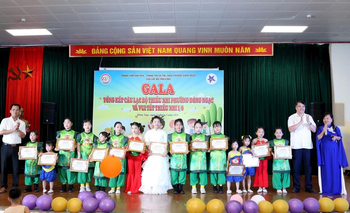 Lãnh đạo Trung tâm Văn hóa - Thông tin và Thể thao phường Đông Ngạc trao Giấy chứng nhận và khen thưởng các học sinh của câu lạc bộ thiếu nhi đã có nhiều thành tích thời gian qua. Ảnh: Mạnh Cảnh