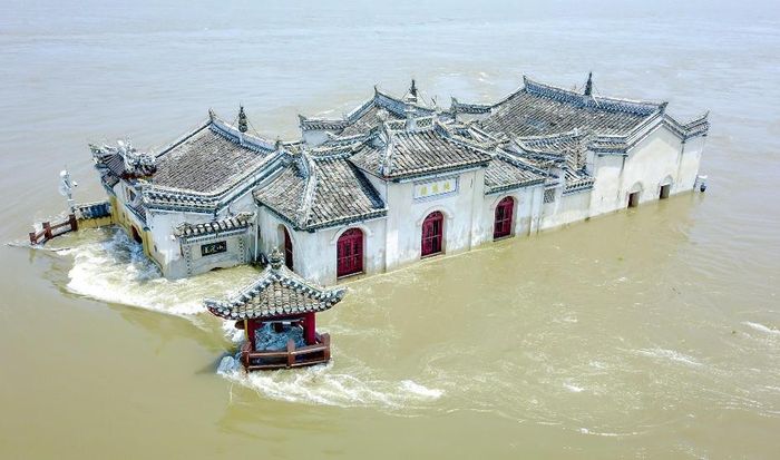  Vào mùa mưa, mực nước sông dâng cao khiến một nửa Quan Âm bị ngập trong nước, chỉ còn lộ ra cửa sổ và mái nhà. Ảnh: VCG. 
