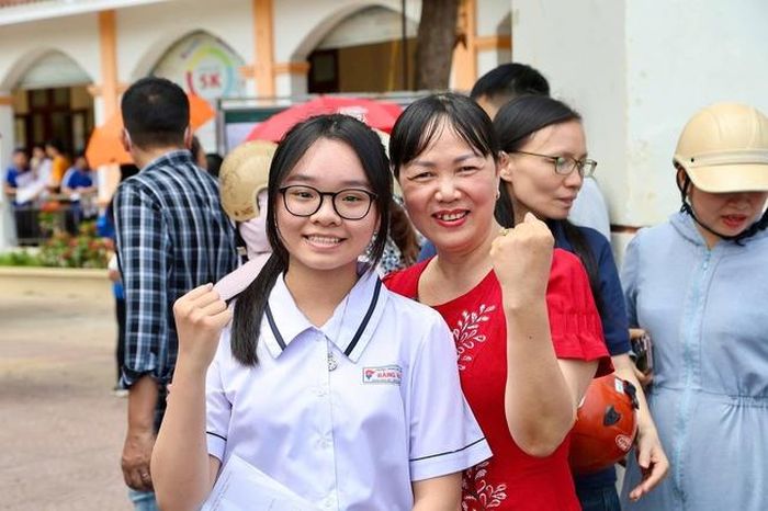 Cô giáo đến cổng trường từ sớm để đón và động viên học trò làm bài tốt. Ảnh: CTTDT HP