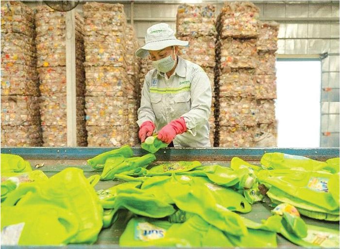 Công nhân làm sạch bao bì nhựa trước giai đoạn tái chế tại nhà máy của Duy Tân Recycling ở Cụm công nghiệp nhựa Đức Hòa Hạ, Tây Ninh. Ảnh: DTR