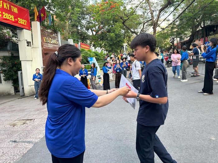 Các tình nguyện viên hỗ trợ thí sinh trước khi vào phòng thi tại điểm thi Trường THCS Ba Đình.
