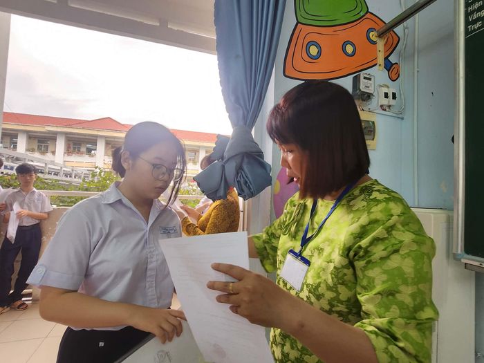  Giám thị kiểm tra phiếu báo danh của thí sinh. Ảnh: NGUYỄN QUYÊN 