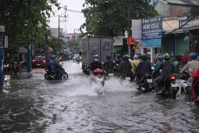  Người dân chật vật di chuyển qua khu vực ngập nước trên đường Nguyễn Tri Phương. Một số phương tiện bị chết máy phải nhờ người hỗ trợ đẩy qua đoạn đường ngập sâu. Ảnh: PHẠM HẢI 