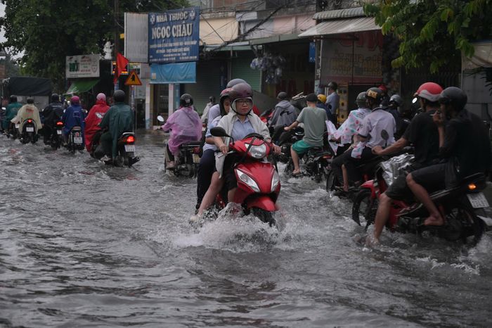  Cơn mưa lớn kéo dài vào chiều 1-6 khiến nhiều tuyến đường tại khu vực Linh Xuân, Dĩ An ngập sâu. Nước dâng nhanh gây khó khăn cho việc đi lại của người dân trong giờ cao điểm tan tầm. Ảnh: PHẠM HẢI 