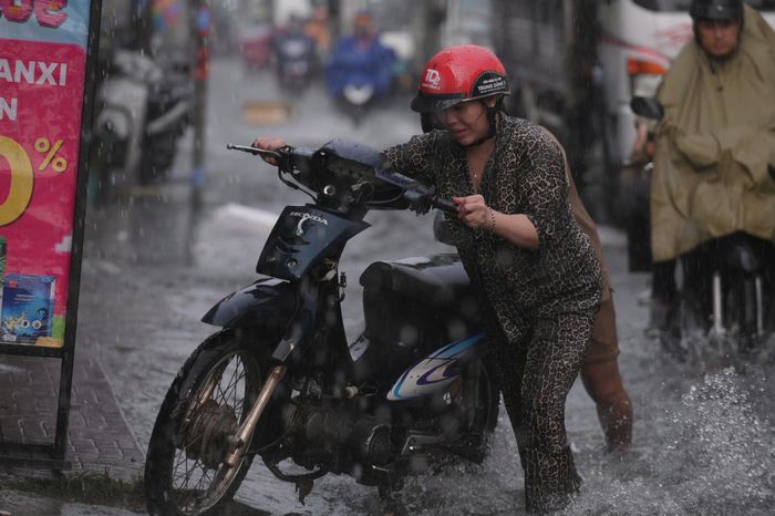  Hàng loạt phương tiện chết máy sau cơn mưa lớn chiều đầu tuần. Người dân vất vả dắt xe qua đoạn đường ngập. Ảnh: PHẠM HẢI 
