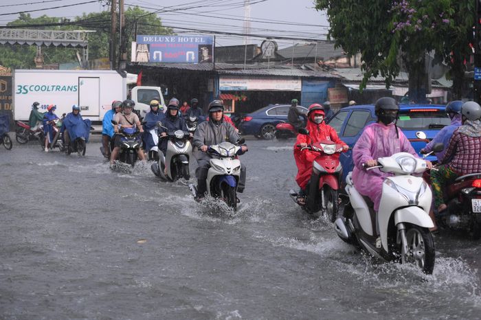  Nước ngập gần nửa bánh xe máy trên đường số 5 khiến nhiều người giảm tốc độ hoặc dắt bộ phương tiện qua đoạn đường ngập. Ảnh: PHẠM HẢI 