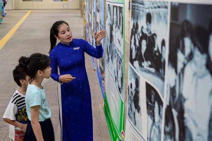  Nhiều phụ huynh dừng lại khá lâu trước từng bảng thông tin để đọc nội dung và giải thích cho con về bối cảnh của những bức ảnh được trưng bày. 