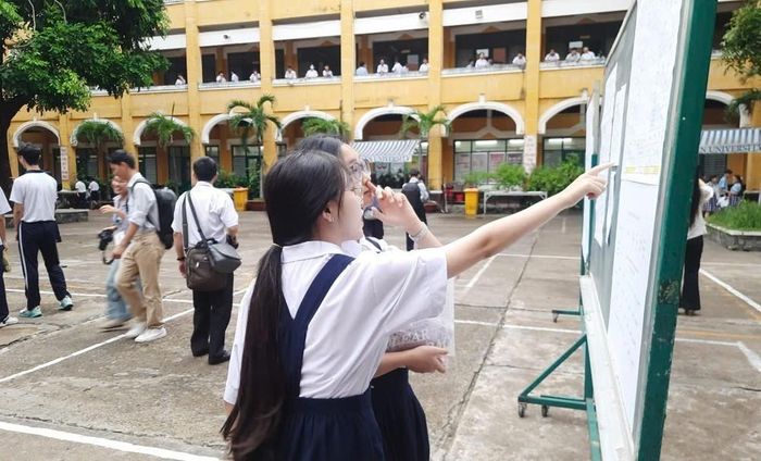 Thí sinh xem danh sách phòng thi tại điểm thi trường THPT Trưng Vương. Ảnh: Thu Hoài - TTXVN