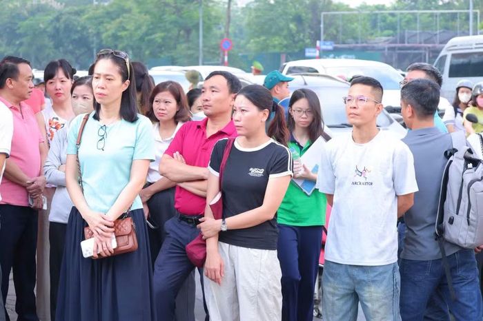 Phụ huynh với tâm trạng lo lắng đứng chờ con trước cổng trường.