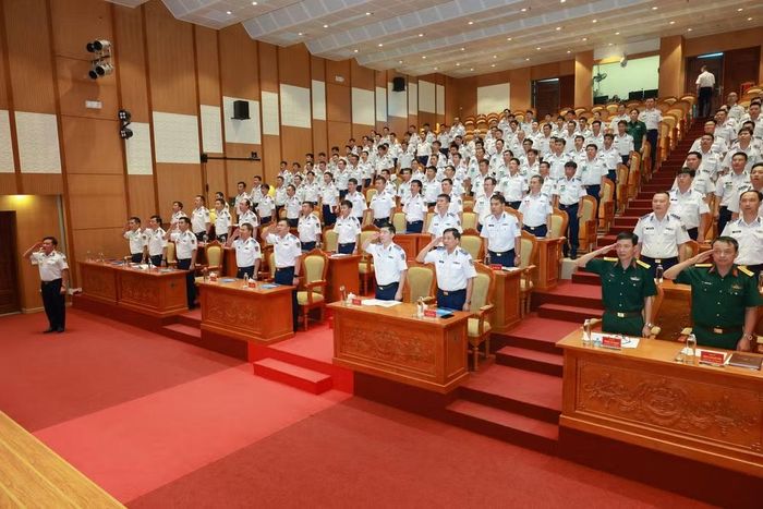 Các đại biểu tham dự lễ khai mạc thực hiện nghi thức chào cờ.