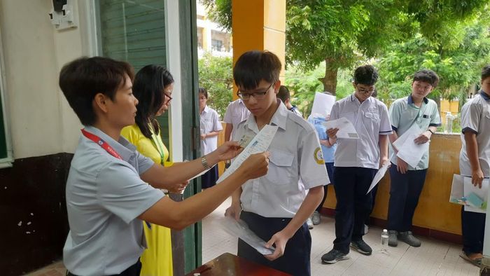 Các thí sinh sinh tại Điểm thi Trường trung học phổ thông Trưng Vương làm thủ tục vào phòng thi.