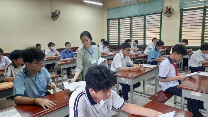 Cán bộ coi thi phát giấy thi cho thí sinh.
