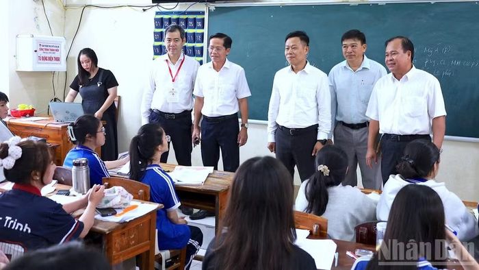 Thứ trưởng Lê Quân (thứ 3 từ phải qua) trò chuyện cùng thầy cô và học sinh tại lớp ôn thi Trường trung học cơ sở và trung học phổ thông Lý Văn Lâm.