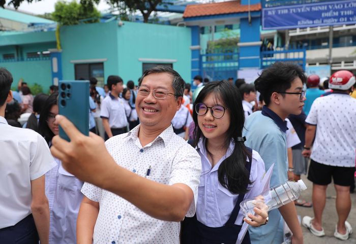 Hai cha con rạng rỡ cùng lưu lại khoảnh khắc kỷ niệm sau khi hoàn thành môn thi đầu tiên của kỳ thi tuyển sinh lớp 10 tại điểm thi Trường THCS Lê Lợi (phường Xuân Hòa, TPHCM)