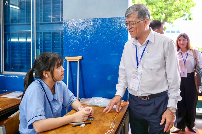 Giám đốc Sở GD-ĐT TPHCM Nguyễn Văn Hiếu động viên tinh thần nữ sinh vì phải chống nạng đi thi