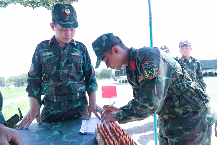 Bộ phận kỹ thuật tiến hành cấp phát đạn cho chiến sĩ mới thực hiện nội dung bắn súng tiểu liên AK bài 1.