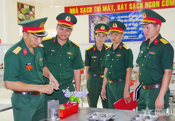 Trung tá Trần Văn Phong (bên trái, ngoài cùng) kiểm tra bảo đảm hậu cần cho bộ đội tại đơn vị. 