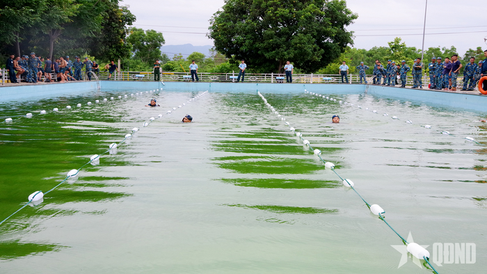 Phần thi bơi vũ trang 100m.