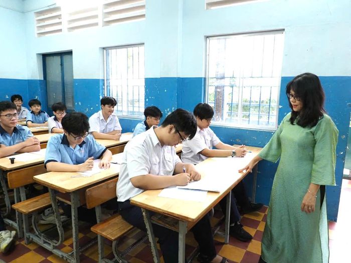  Cán bộ coi thi cho thí sinh kiểm tra thông tin cá nhân tại điểm thi THCS Lê Lợi. Ảnh: THU TÂM. 