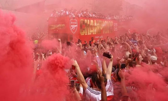 Khói pháo sáng nhuộm đỏ không gian khi đoàn xe của Arsenal đi qua. Thất bại trước PSG trong loạt sút luân lưu ở chung kết Champions League một ngày trước đó không thể làm nguội bầu không khí lễ hội.